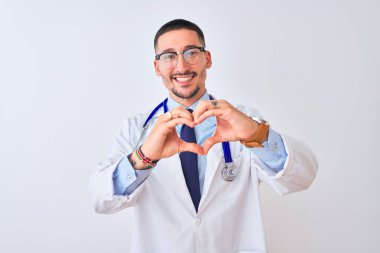 Soyutlanmış arka planda steteskop takan genç bir doktor. Elleriyle kalp sembolü yapan bir aşkla gülümsüyor. Romantik konsept.