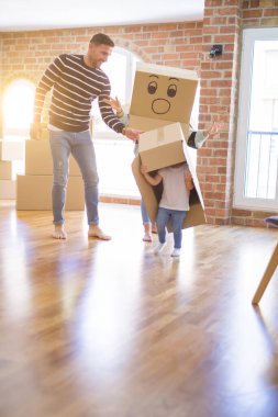 Yeni evde karton bel kutuları ile oynayan çocuk ile güzel famiily