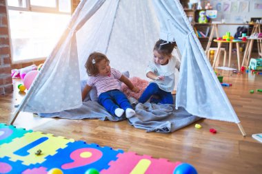 Sevimli bebekler, Tip 'in içinde, anaokulunda sırıtarak battaniyenin üzerine uzanırlar.