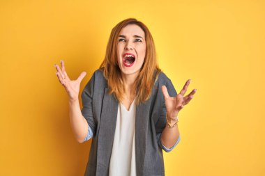 Kızıl saçlı Kafkas iş kadını, öfkeyle bağırırken öfkeli ve öfkeli bir şekilde arka planı izole etti. Öfke ve agresif kavram.