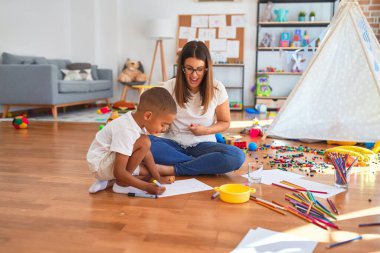 Genç, güzel bir öğretmen ve Afrikalı bir Amerikalı çocuk. Anaokulunda bir sürü oyuncağın etrafına kağıt ve kalem çizerek oturmak.