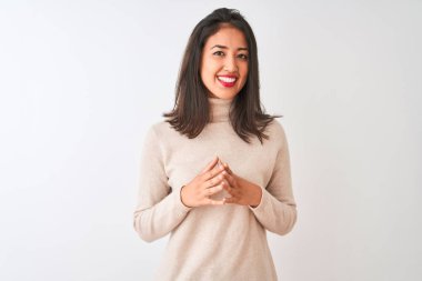 Balıkçı yaka kazak giyen güzel Çinli kadın izole edilmiş beyaz arka plan üzerinde duruyor eller yan yana ve parmaklar çapraz gülümseyerek gevşemiş ve neşeli. Başarı ve iyimser