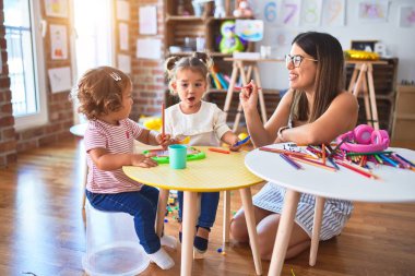 Anaokulunda plastik yemek ve çatal bıçak kullanarak yemek oynayan genç ve güzel öğretmenler.