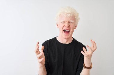 Siyah tişörtlü genç albino adam izole edilmiş beyaz arka planda duruyor. Deli gibi bağırıyor ve agresif bir ifade ve kollarla bağırıyor. Hayal kırıklığı konsepti.