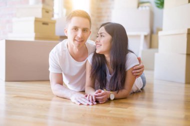 Genç güzel çift karton kutular etrafında yeni evde yatarken