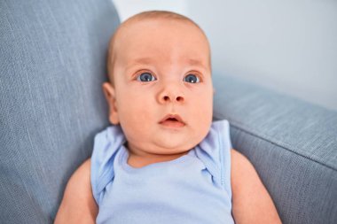 Evdeki kanepede uzanmış sevimli bir bebek. Yeni doğmuş bebek rahatlıyor ve dinleniyor.