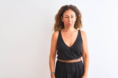 İzole edilmiş beyaz arka planda dikilen siyah günlük elbise giyen orta yaşlı bir kadın depresif, sinirli ve korkmuş bir şekilde ağlıyor. Üzücü ifade.