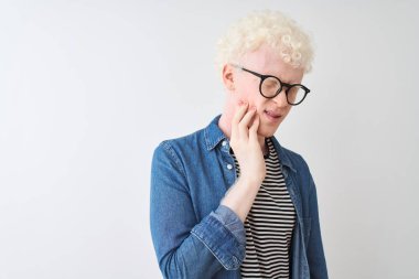 Kotlu gömlek ve gözlük takan genç albino adam diş ağrısı ya da diş ağrısı yüzünden ağza dokunuyor. Dişçi konsepti.