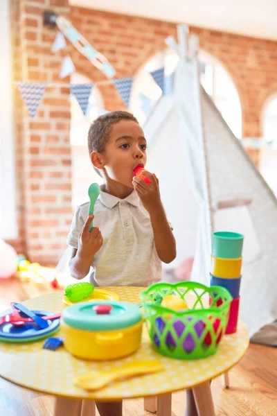 漂亮的非洲裔美国幼儿在幼儿园玩塑料食品和餐具玩具 — 图库照片