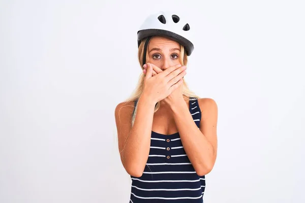 年轻漂亮的女人戴着自行车头盔 站在孤立的白色背景上 双手捂住嘴 为自己的错误而震惊 秘密概念 — 图库照片