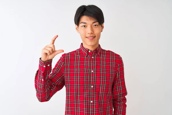 孤立した白い背景の上に立つカジュアルな赤いシャツを着て若い中国人男性は笑顔と指を見て カメラと小さなサイズの看板を行う手で自信を持ってジェスチャー 概念の測定 — ストック写真