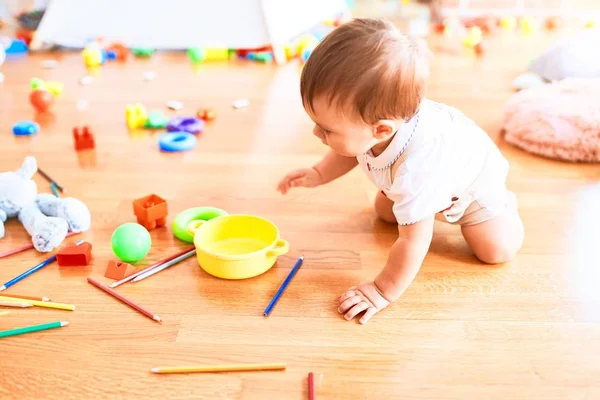 Anaokulunda Bir Sürü Oyuncak Arasında Emekleyen Sevimli Bir Çocuk — Stok fotoğraf