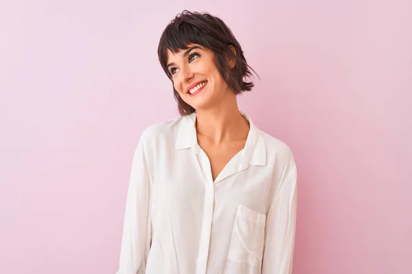 若い美しい女性の白いシャツ孤立したピンクの背景の上に顔に笑顔で横に離れて見て立って着て 自然な表情 自信を持って — ストック写真