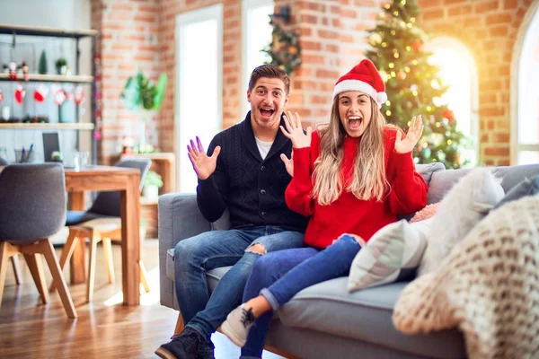 Ein Junges Paar Mit Weihnachtsmannmütze Sitzt Hause Auf Dem Sofa — Stockfoto