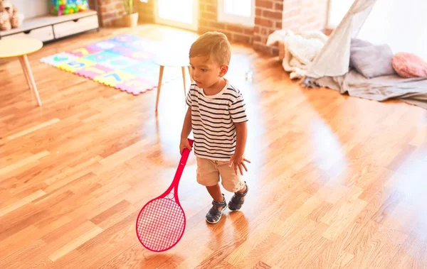 可爱的幼儿在幼儿园用红色球拍和球打网球 — 图库照片