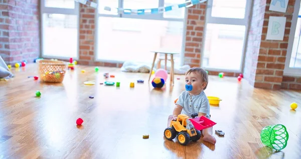 Adorável Criança Sentada Chão Usando Chupeta Brincando Torno Lotes Brinquedos — Fotografia de Stock