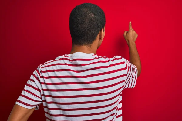 Junger Gutaussehender Arabischer Mann Trägt Gestreiftes Shirt Über Isoliertem Rotem — Stockfoto