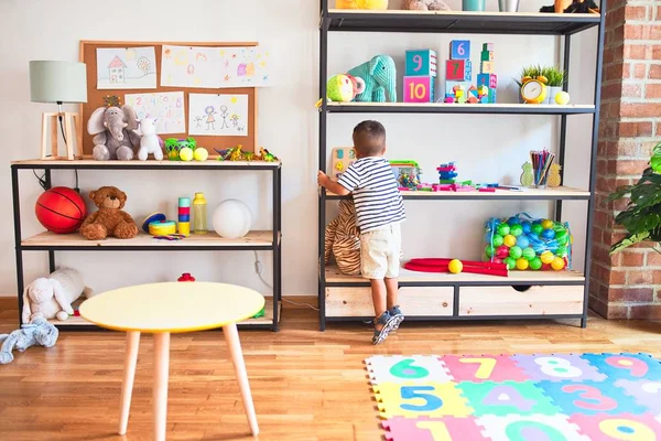 Schöner Kleinkind Junge Steht Mit Vielen Spielsachen Kindergarten — Stockfoto