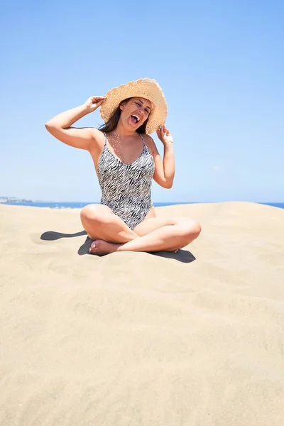 若いです美しいです女性日光浴上の砂身に着けています夏の水着にMaspalomas砂丘Bech — ストック写真