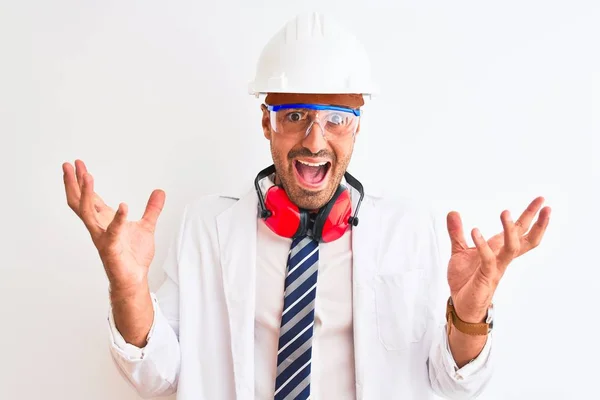 年轻的化学家 头戴安全帽 头戴耳机 站在与世隔绝的背景上 兴奋地欢呼着 欢呼着 欢呼着成功 赢的概念 — 图库照片