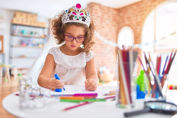 幼稚园内戴眼镜 头戴王冠 手握纸笔的漂亮幼儿 — 图库照片