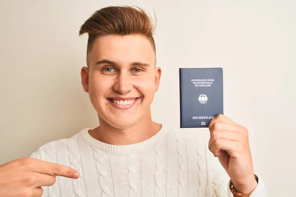 Młody Przystojny Mężczyzna Trzyma Niemiecki Paszport Odizolowanym Białym Tle Zaskakującą — Zdjęcie stockowe