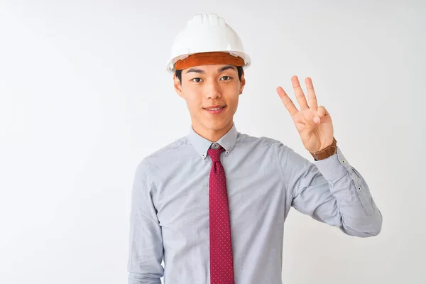 中国建筑师头戴领带 头戴头盔 站在孤独的白色背景上 用第三根手指指指着 面带微笑 自信而快乐 — 图库照片