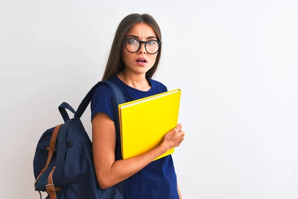 Junge Studentin Mit Rucksackbrille Buch Über Isoliertem Weißem Hintergrund Erschrocken — Stockfoto