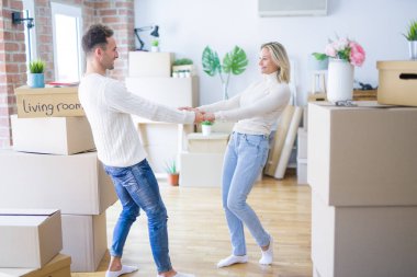 Karton kutular etrafında yeni evde dans genç güzel çift