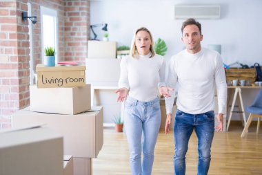 Genç ve güzel bir çift yeni evlerinde karton kutuların etrafında duruyor. Şaşırmış ve korkmuş bir ifade, korku ve heyecanlı bir yüz..