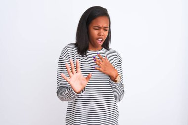 Üzerinde kış kazak giyen güzel genç Afro-Amerikan kadın arka plan korkuyor ve korku ifade dur hareketi el ile ile dehşete şokta bağırarak izole. Panik kavramı.