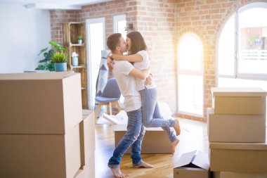 Karton kutular etrafında yeni evde sarılma genç güzel çift