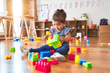 Anaokulundaki oyuncaklarla oynayan güzel bir çocuk.