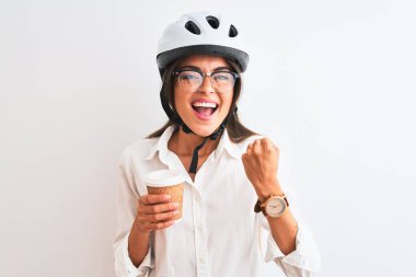 Bisiklet kaskı takan güzel bir iş kadını izole edilmiş beyaz arka planda kahve içiyor gururla bağırıyor, zaferi ve başarıyı kutluyor çok heyecanlı, coşkulu bir duygu.