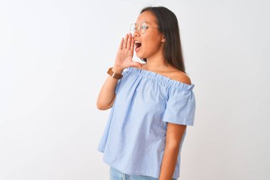 Mavi tişört ve gözlük takan Çinli genç bir kadın izole edilmiş beyaz arka planda avazı çıktığı kadar bağırıyor ve ağızdan ağıza bağırıyordu. İletişim konsepti.