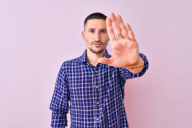 Arka planda duran yakışıklı genç adam avucunun içi gibi şarkı söylemeyi kesiyor. Yüzünde olumsuz ve ciddi bir jest olan uyarı ifadesi.