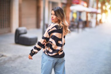 Mutlu ve kendinden emin gülümseyen genç ve güzel bir kadın. Şehir caddesinde ayakta ve yürüyorum.