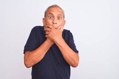 İzole edilmiş beyaz arka planda duran siyah polo giyen yaşlı gri saçlı adam yanlışlıkla ağızlarını kapatarak şok geçirdi. Gizli konsept.