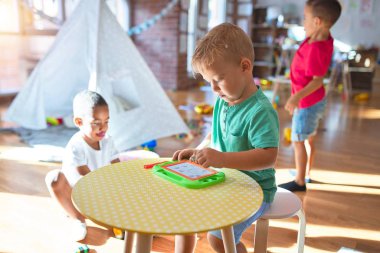 Anaokulunda bir sürü oyuncakla oynayan sevimli çocuklar.