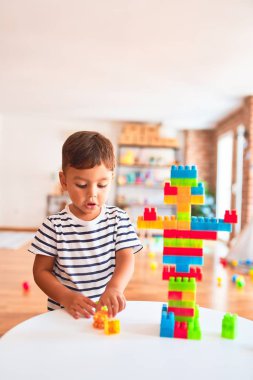 Güzel çocuk anaokulunda inşaat bloklarıyla oynuyor.