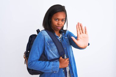 Afrika kökenli Amerikalı genç bir bayan sırt çantası takıyor. Arka planı açık, dur işareti yapıyor. Ciddi ve kendinden emin bir ifadeyle, savunma hareketi yapıyor.