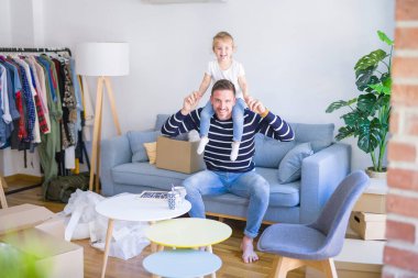 Genç ve yakışıklı baba, güzel bebeğini omuzlarında tutuyor.