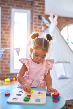 Anaokulunda matematik oyunu oynayan genç ve güzel bir çocuk.