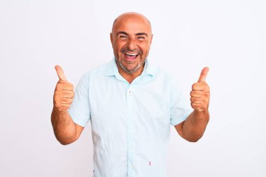 İzole edilmiş beyaz arka plan başarısı tabelasının üzerinde dikilmiş orta yaşlı yakışıklı bir adam elleriyle olumlu jest yapıyor, gülümseyerek ve mutlu. Neşeli ifade ve kazanan jest.