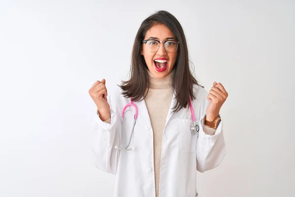 隔離された白い背景にコートとピンクの聴診器を身に着けている中国の医師の女性は驚きを祝い 腕を上げて開いて目で成功に驚いています 勝者のコンセプト — ストック写真