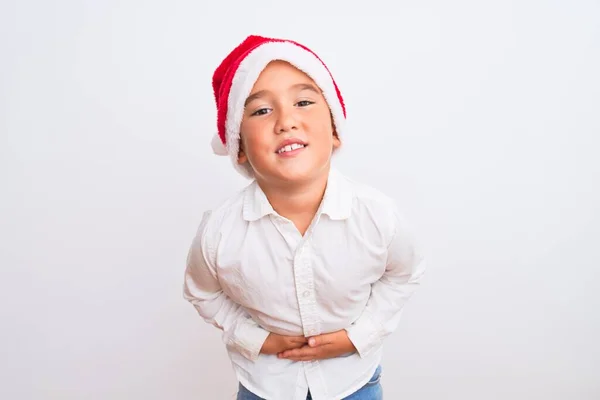 漂亮的小男孩戴着圣诞圣诞礼帽 手托着肚子站在孤独的白色背景上 因为恶心 痛苦的疾病感觉不舒服 阿切概念 — 图库照片