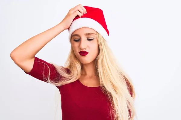 孤立した白い背景の上にクリスマスのサンタの帽子を身に着けている若い美しい女性は混乱し 質問について不思議 疑いもなく 頭の上で手で考えて 包括的概念 — ストック写真