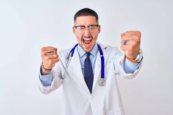怒りと怒りで叫んでいる間に孤立した背景に聴診器を身に着けている若い医者の男は怒りと怒りの拳を上げる 激怒と積極的な概念 — ストック写真
