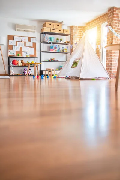 Picture of preschool playroom with colorful furniture, and toys around empty kindergarten