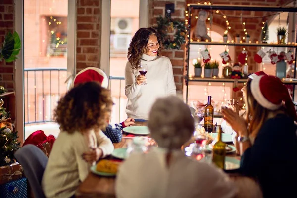 一群漂亮的女人开心而自信地微笑着 他们中的一个举着酒杯在家里庆祝圣诞节的讲演 — 图库照片